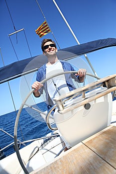 Man skipper navigating a sailing boat photo