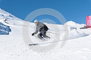 A man with skis stands high in the mountains enjoying the scenery. Go downhill skiing, extreme relaxation