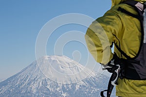 Man in skiwear standing looking at snow-capped mountain, Hokkaido