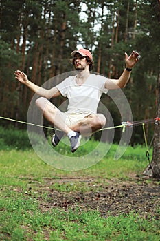 Man slacklining balancing on a rope, slackline in forest photo