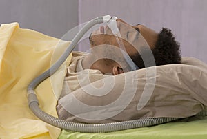 Man with sleep apnea using a CPAP machine