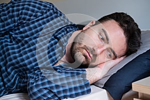 Man with sleep disorder lying in the bed