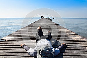 Man sleep on Wooden bridge to the sea for relaxing