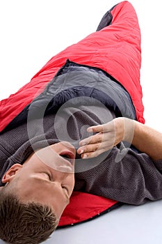 Man in sleeping bag and yawning