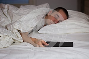 Man sleeping in bed and holding a tablet computer