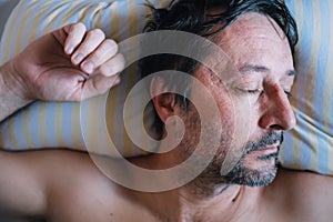 Man sleeping in bed on a pillow in morning