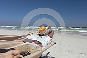 Man sleeping on hammock at beach