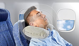 Man sleeping in plane with cervical neck pillow