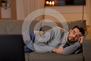 Man sleeping on sofa with tv remote at home