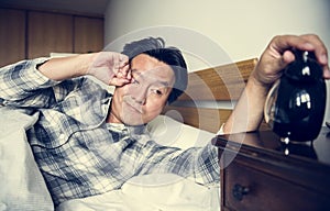A man sleeping soundly waking from alarm photo