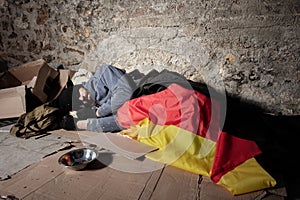 Man sleeping on the street under German flag photo
