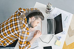 Man sleeping on table with laptop