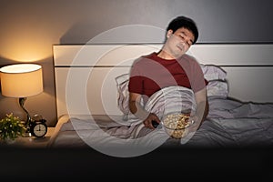 Man sleeping while watching tv on a bed at night