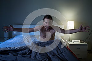 Man sleepless in his bed screaming after nightmare