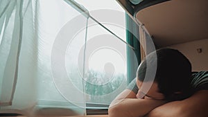 Man sleeps in train tired long journey by rail. Train railroad journey travel. Slow motion video. Beautiful from window
