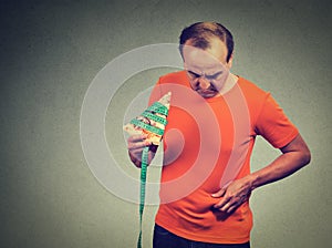 Man with slice of pizza measuring tape and overweight abdomen.