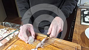 A man slices an onion into rounds. Slicing peeled onions into rings. The concept of culinary and gastronomy