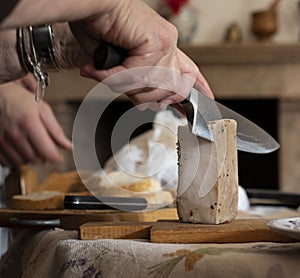 Man slicing a block of lard with a chefs knife