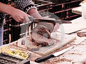 Man slicing bread on market