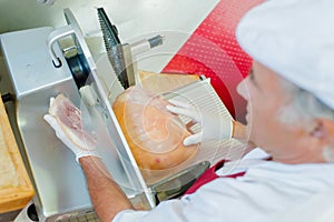 Man slicing meat with machine view from above