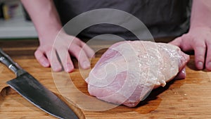 Man slicing pork meat on a table, conceptual idea. Healthy, preparing.