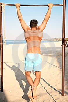 Man with slim body doing pull-ups