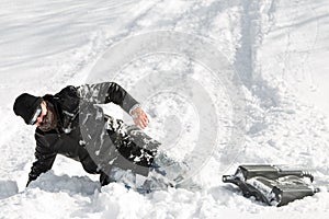 Man slumping in the deep snow after a sleigh ride with a sledge