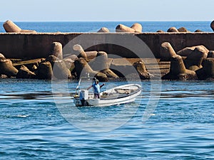 Man In Small Boat At Ilha De Baretta Portugal