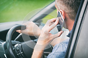 Man with smart phone in the car