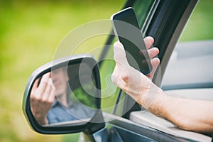 Man with smart phone in the car