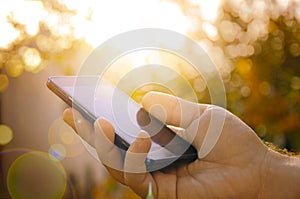 Man with smart phone on hand, blurred background