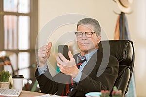 Man with Smart Phone in his office