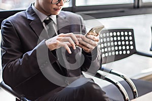 Man on smart phone - young business man in airport. Casual urban