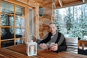 Man with smartphone and cup of tea