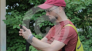 Man with smartphone and folding bicycle