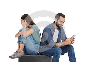 Man with smartphone ignoring his girlfriend on background. Relationship problems