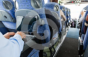 Man with smartphone and laptop in travel bus