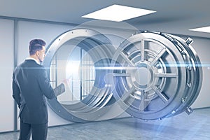 Man with smartphone standing near blue vault