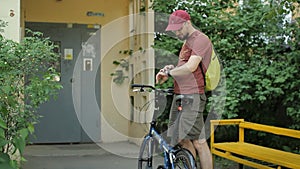 Man with smartwatch and folding bicycle