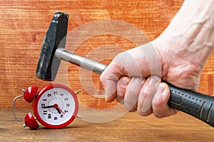 A man smashes an alarm clock with a hammer