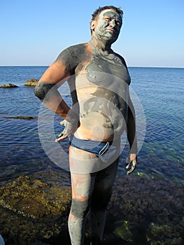 Man, smeared by mud at sea photo