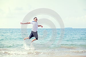 A man smile and jump in sea water and water splash. Travel summer, relax Concept