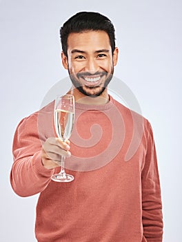 Man with smile in portrait, champagne and cheers with celebration and happiness isolated on studio background. Toast