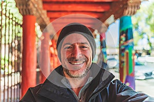 Man smiles at camera in foreground against dynamic orange red breezeway