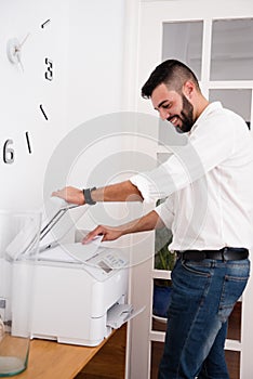 Man smiling as he uses a photo copier