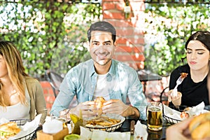 Man Smiling While Eating Unhealthful Food With Women