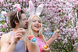 Man and smiling girl with bunny ears holding eggs