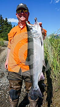 Man Smiling Holding Big Alaska Silver Salmon