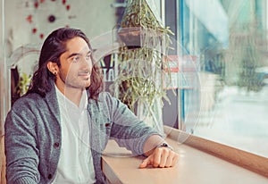 Man smiling looking through the window thoughtful daydreaming