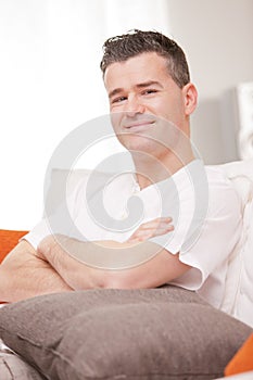 Man smiling to camera relaxing in his living room